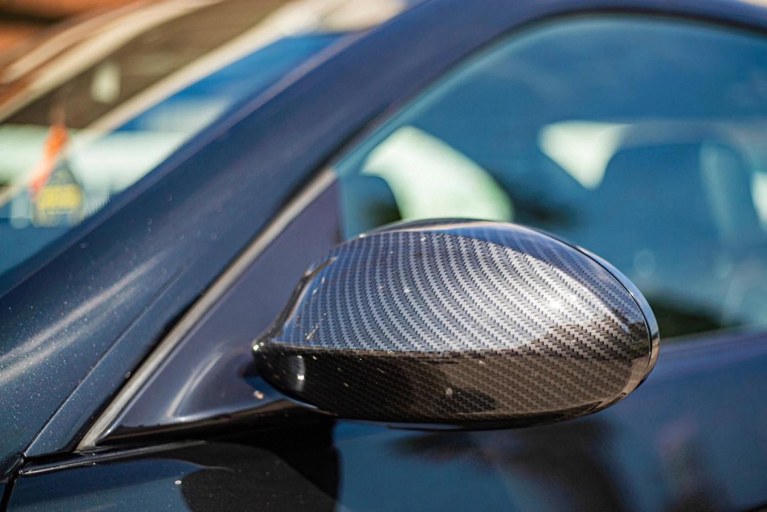 Close-up of a car wing mirror and body panel showing paint condition on a rental vehicle