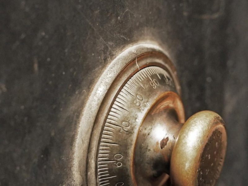Close-up of a tarnished combination dial on an ageing metal safe